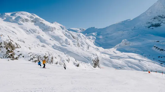 Groupe de randonneurs équipés de bâtons et de vêtements chauds traversant un paysage montagneux enneigé