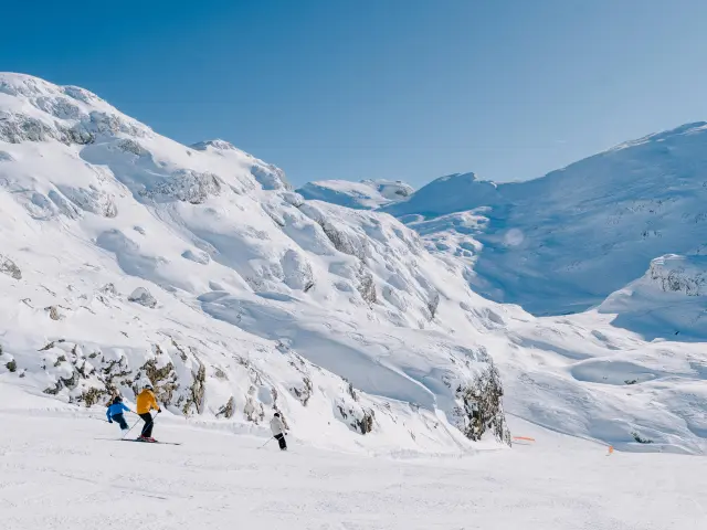 Groupe de randonneurs équipés de bâtons et de vêtements chauds traversant un paysage montagneux enneigé