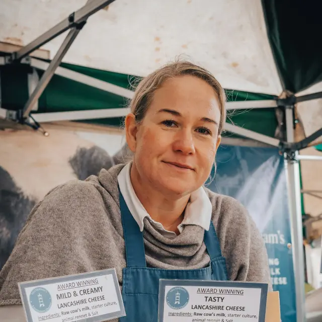 Femme tenant un carton de produits alimentaires avec un badge de dégustation