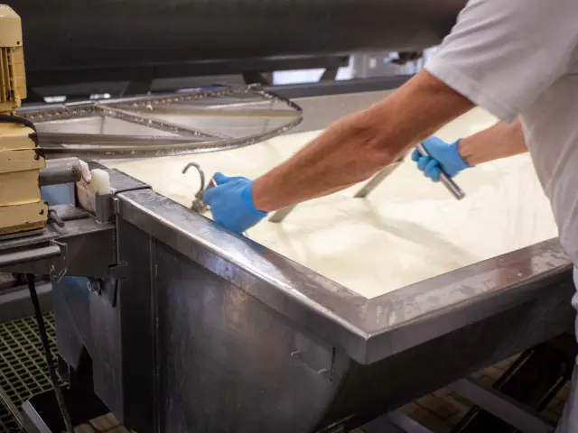 Cuisinier en blouse blanche préparant des plats sur un plan de travail en inox