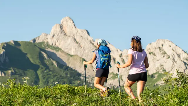 Two people in hiking gear walking on a mountain trail