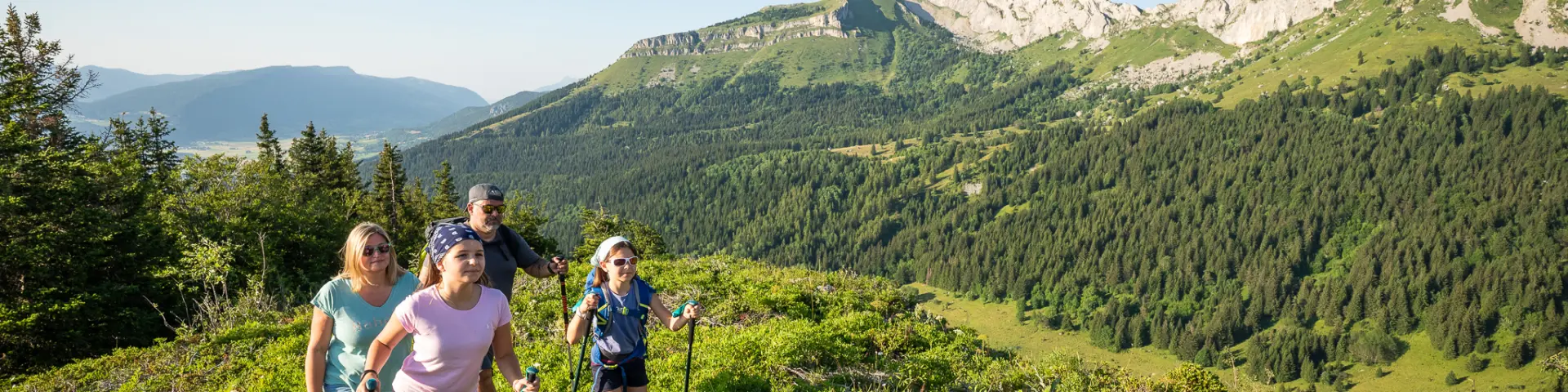 Tre persone che camminano su un sentiero di montagna circondate da vegetazione