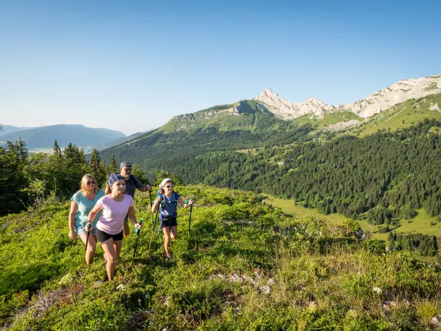 Tre persone che camminano su un sentiero di montagna circondate da vegetazione