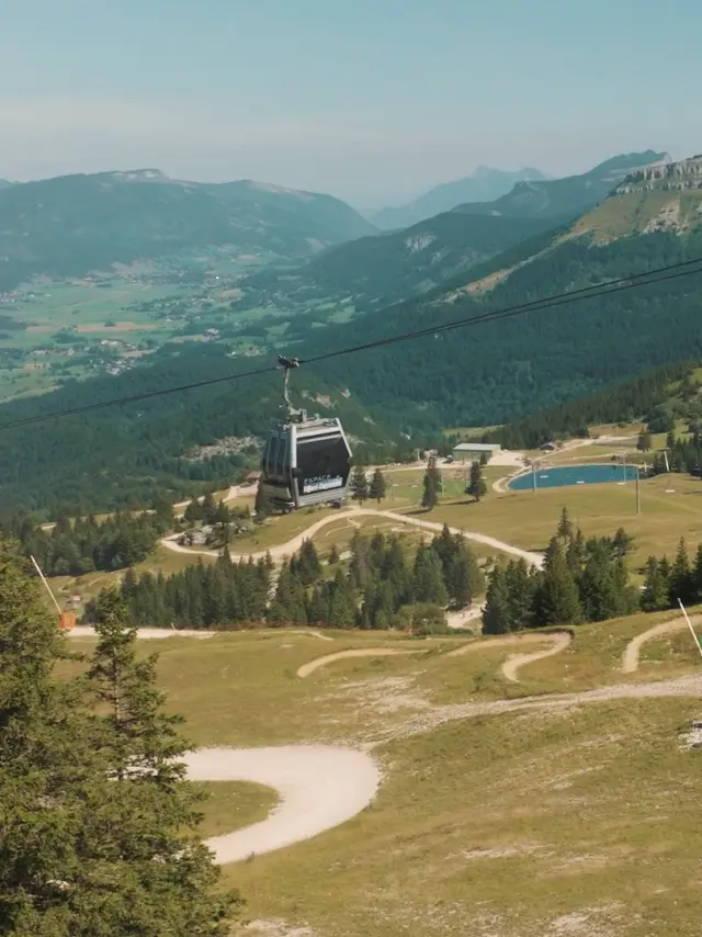 Route sinueuse en montagne avec des bâtiments et des voiliers amarrés dans une vallée