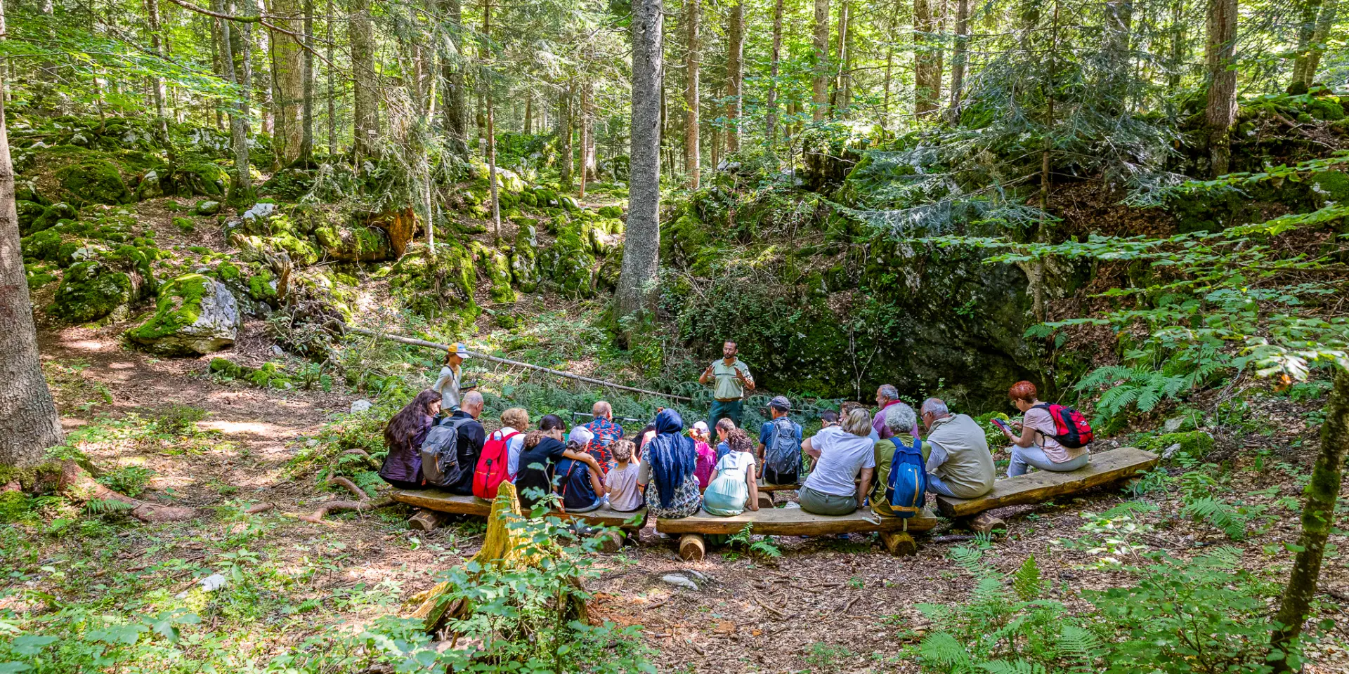 Groupe de randonneurs assis sur des troncs d'arbres dans une forêt