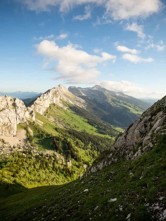 Escursionista in piedi su una roccia in montagna con vista su una valle