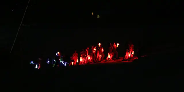 Voiliers amarrés éclairés par des lumières rouges au crépuscule