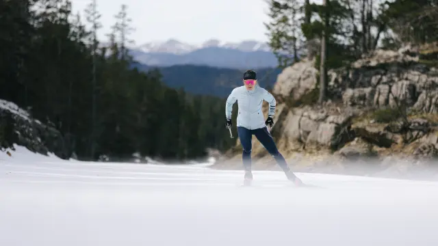 Persona che pratica lo sci di fondo su una pista innevata in montagna