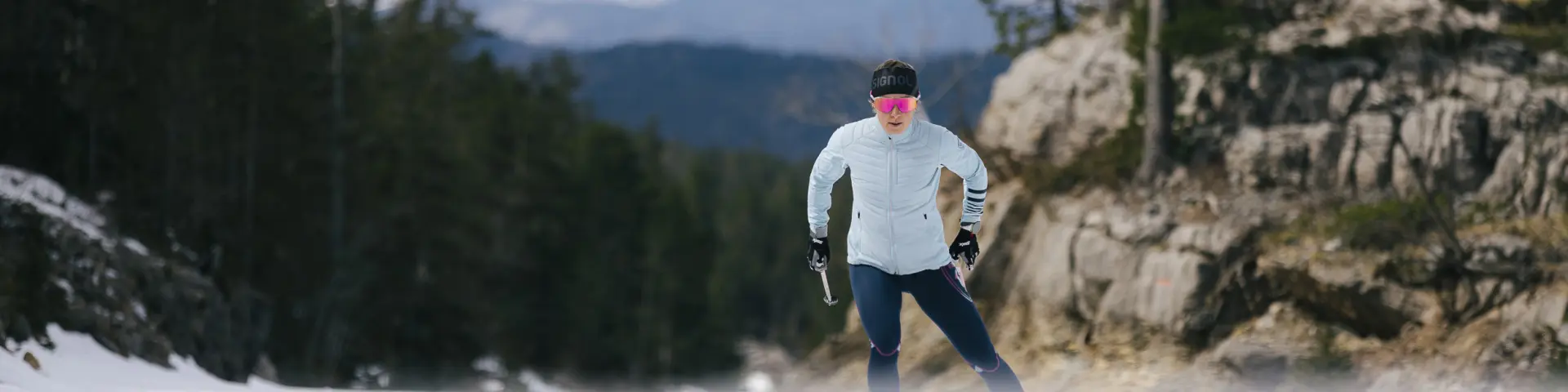 Personne pratiquant le ski de fond sur une piste enneigée en montagne