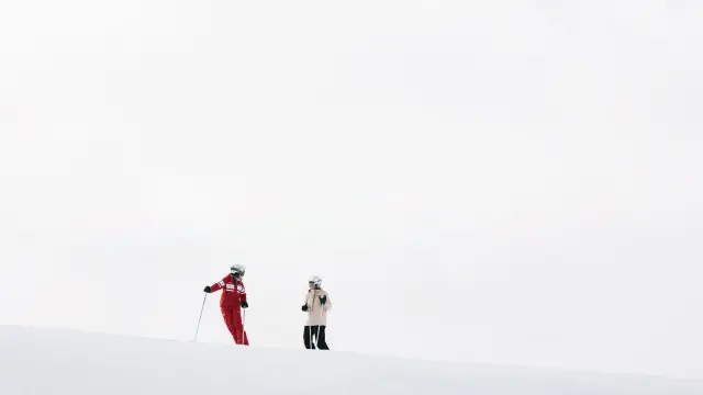 Due sciatori con bastoncini e abbigliamento da sci in una zona innevata con nebbia