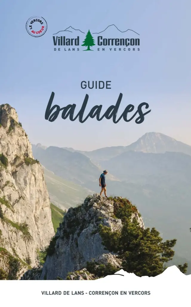 Paysage montagneux avec un randonneur en haut d'un rocher, guide de balades en arrière-plan