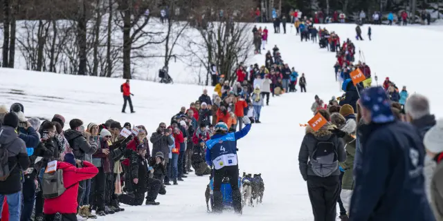 Personnes en tenue de ski marchant et discutant dans une station de montagne enneigée