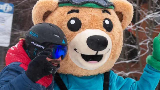 Enfant portant un déguisement d'ours polaire avec bonnet et écharpe