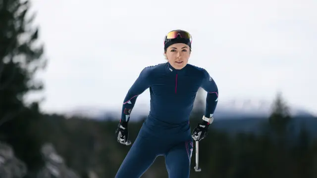 Cycliste portant un casque et un gilet bleu sur un vélo de route en forêt