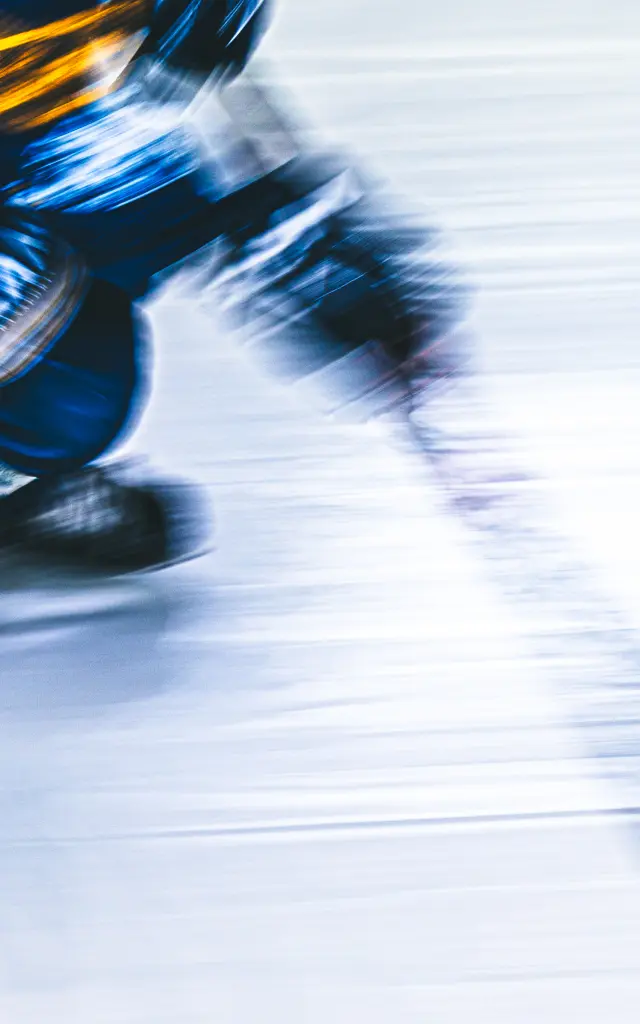 Patin à glace bleu et noir en mouvement sur une piste glacée