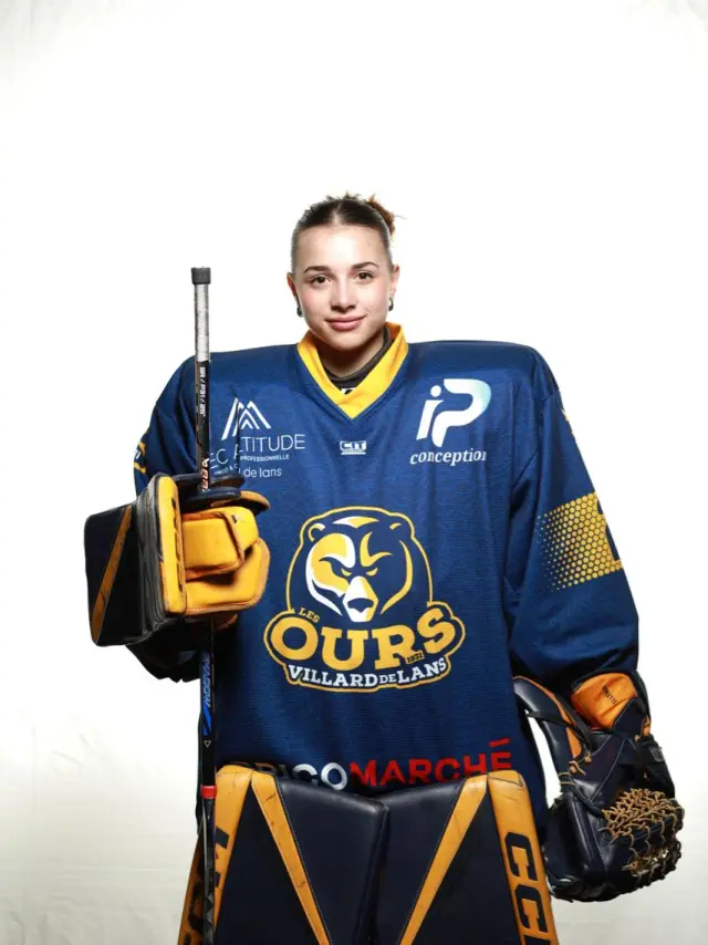 Footballeur en tenue bleue du FC Nantes tenant un trophée devant un micro