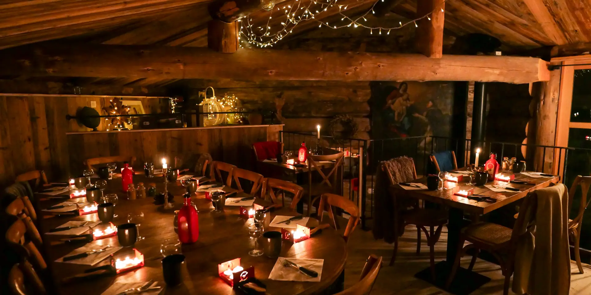 Intérieur d'un restaurant avec tables dressées, clients attablés et éclairage chaleureux