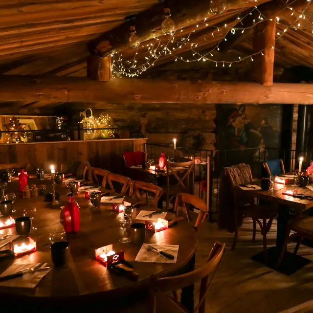 Intérieur d'un restaurant avec tables dressées, clients attablés et éclairage chaleureux