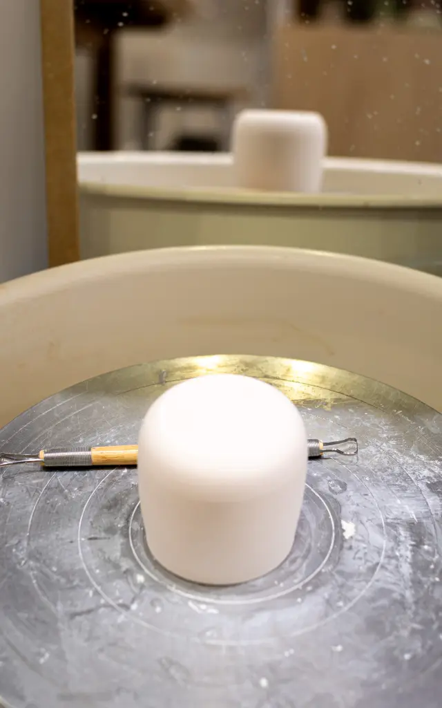 Bottiglia d'acqua trasparente con tappo bianco posizionata su una scrivania di legno