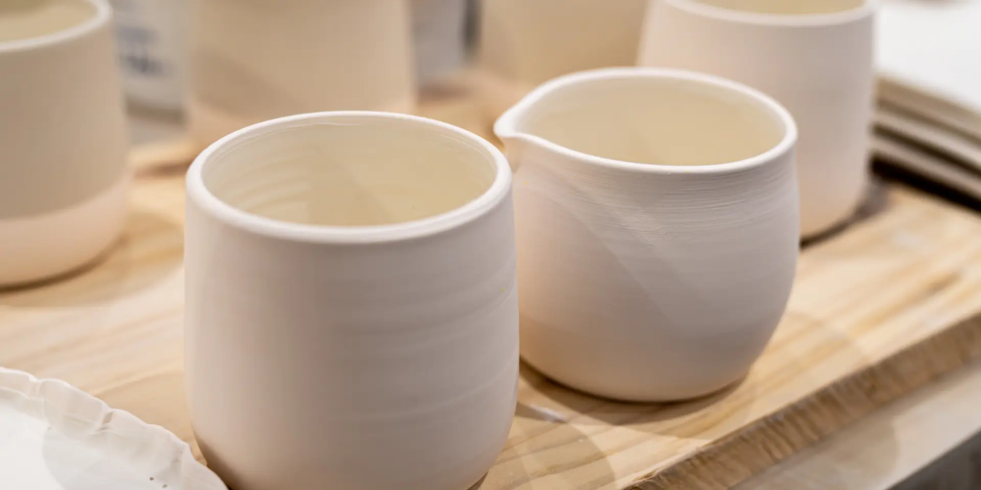 Due ciotole di ceramica bianca contenenti un liquido dorato, posate su un tavolo di legno