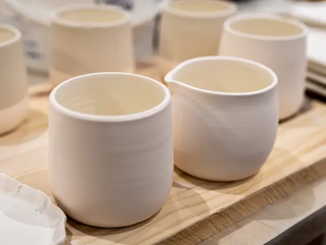 Due ciotole di ceramica bianca contenenti un liquido dorato, posate su un tavolo di legno