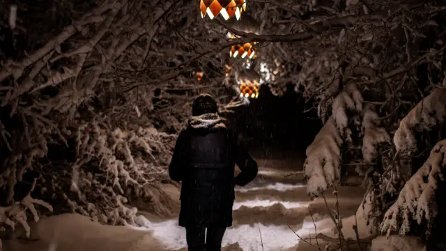 Persona in abbigliamento da escursionismo che esplora una grotta illuminata da faretti