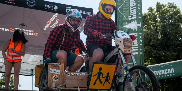 Two custom Triumph motorcycles displayed side by side with helmets and accessories