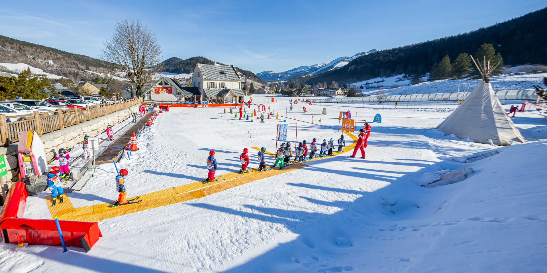 Station de ski avec remontées mécaniques, pistes damées et skieurs en activité