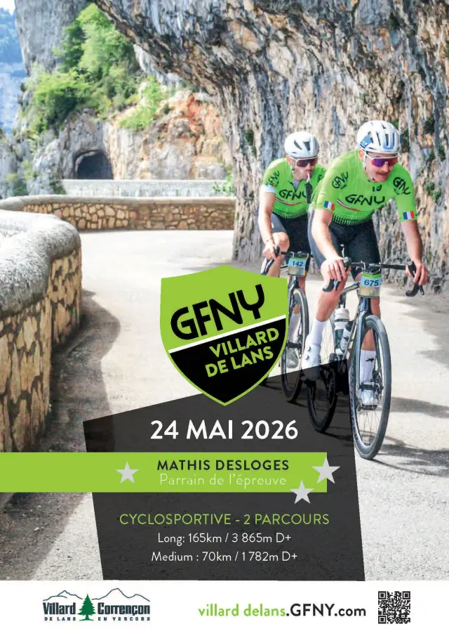 Deux cyclistes en tenue verte et noire en compétition sur une route bordée de rochers et de végétation