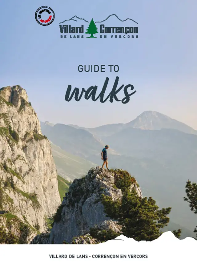 Copertina di una guida escursionistica che mostra un sentiero di montagna con escursionisti e paesaggi alpini sullo sfondo